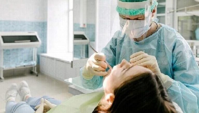 طبيب يعالج أسنان مريضة