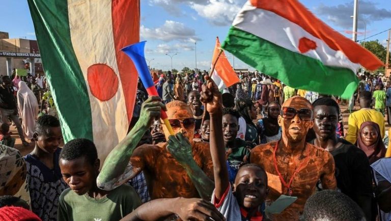 أحد أنصار قادة الانقلاب في النيجر يحمل ديكا مطليا بألوان العلم الفرنسي