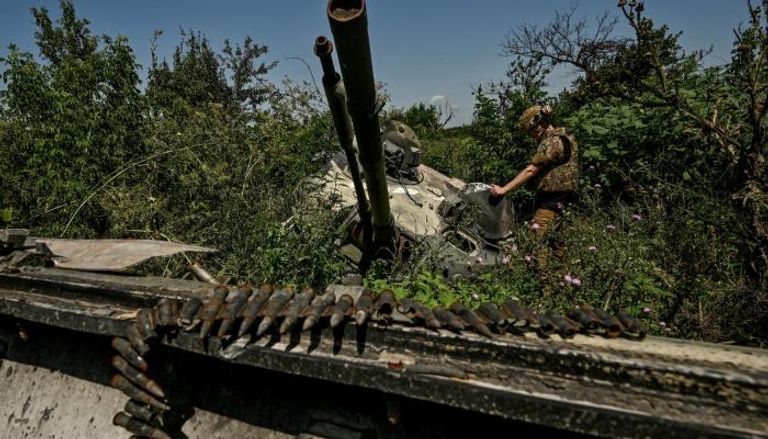 جندي أوكراني يعاين دبابة روسية معطوبة - أرشيفية