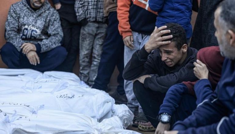 شاب يبكي أمام جثث أفراد من عائلته في غزة