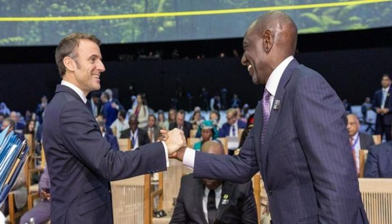 الرئيس الكيني ويليام روتو يصافح نظيره الفرنسي إيمانويل ماكرون في COP28