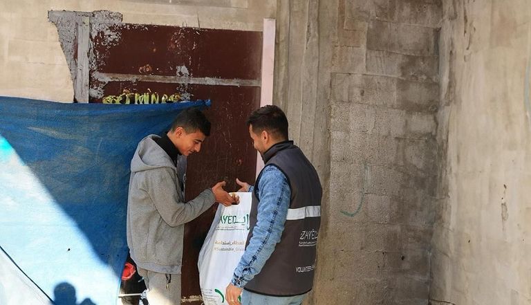 طفل يتسلم طردا غذائيا