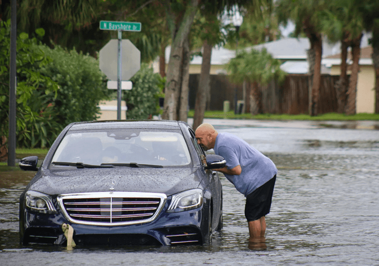 رجل يعبر منطقة غمرتها المياه على ساحل جولفبورت بولاية فلوريدا