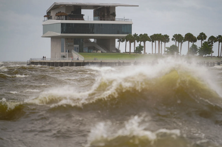 رجل يعبر منطقة غمرتها المياه على ساحل جولفبورت بولاية فلوريدا