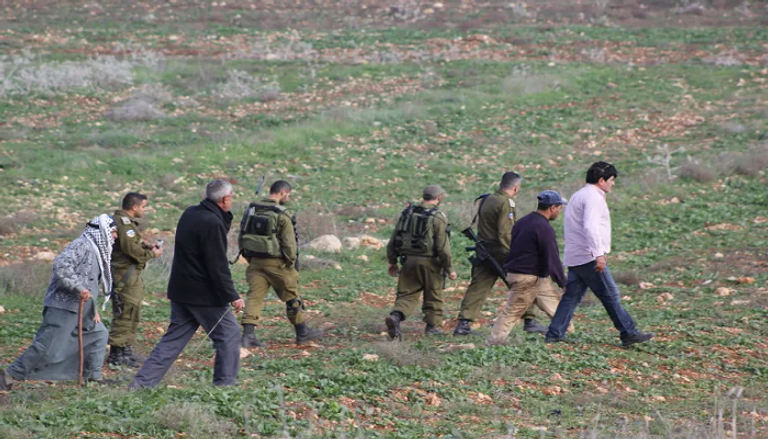 فلسطينية تدافع عن أشجار الزيتون بأرضها