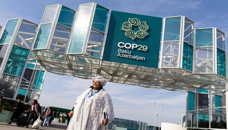 سيدة مشاركة في COP29 أمام مقر انعقاد المؤتمر