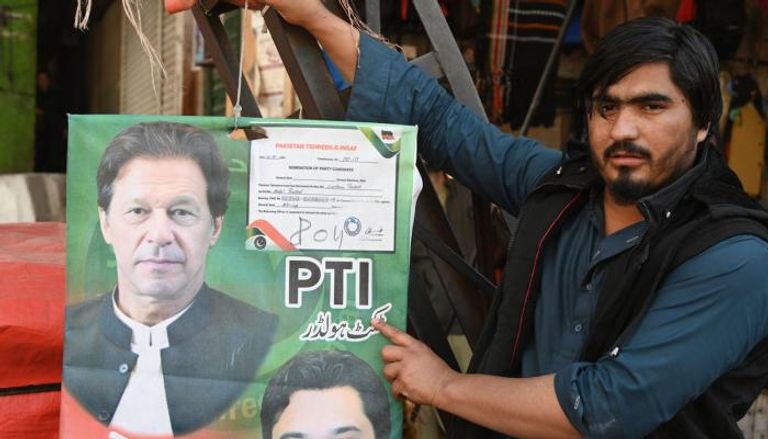 بائع يحمل ملصقا عليه صورة عمران خان