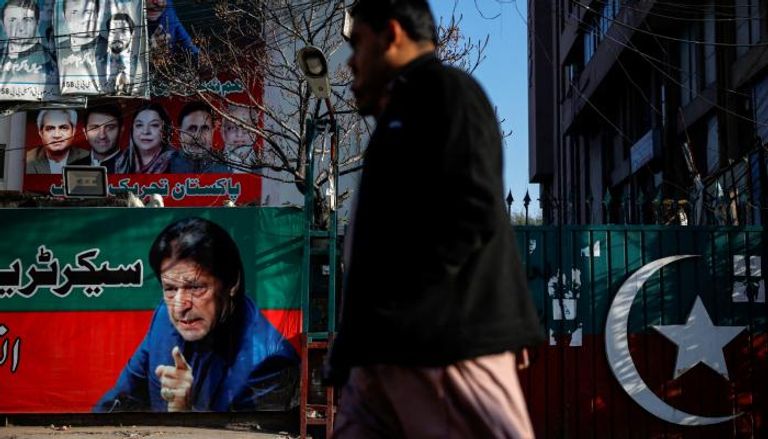 باكستاني يمر قرب لافتة تحمل صورة خان