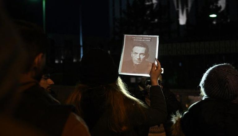 أشخاص يحملون لافتات خارج السفارة الروسية في واشنطن بعد وفاة زعيم المعارضة الروسية أليكسي نافالني