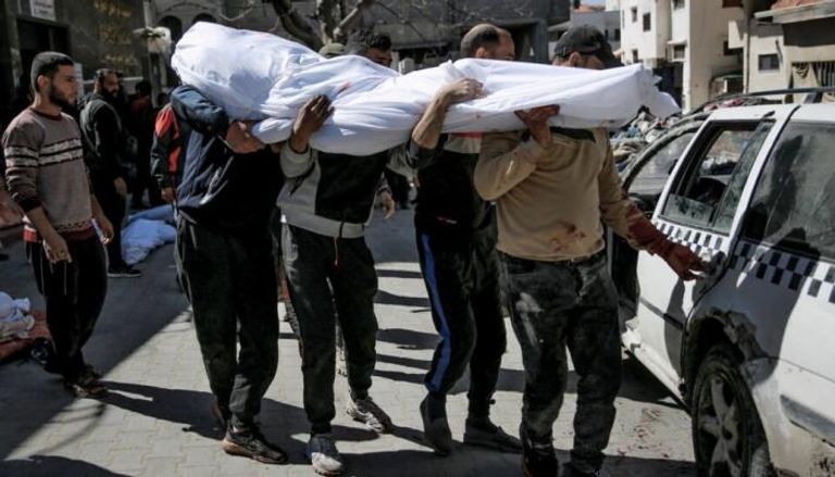 رجال يحملون جثة فلسطيني من ضحايا «مجزرة الدقيق»