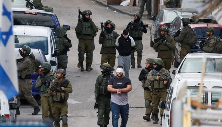 قوات إسرائيلية تعتقل فلسطينيا في رام الله - رويترز