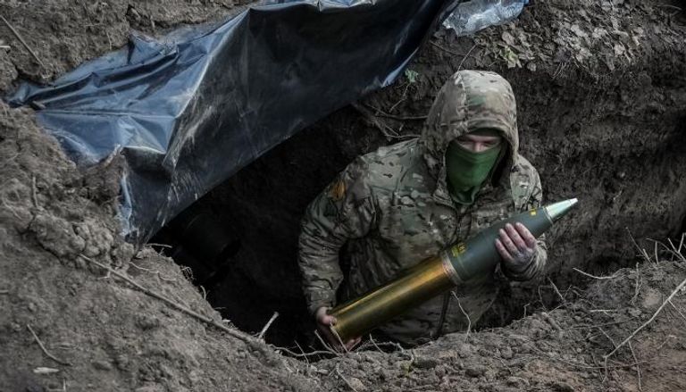 جندي أوكراني يحمل قذيفة مدفعية