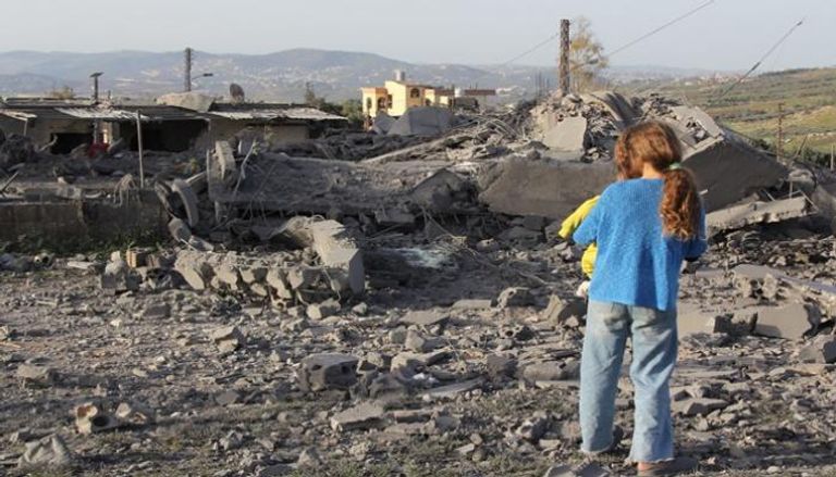 فتاة تتفقد الأضرار التي لحقت بمبنى بعد يوم من غارة إسرائيلية على قرية بلبنان