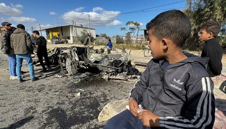 طفل فلسطيني ينظر لحطام سيارة في رفح - رويترز