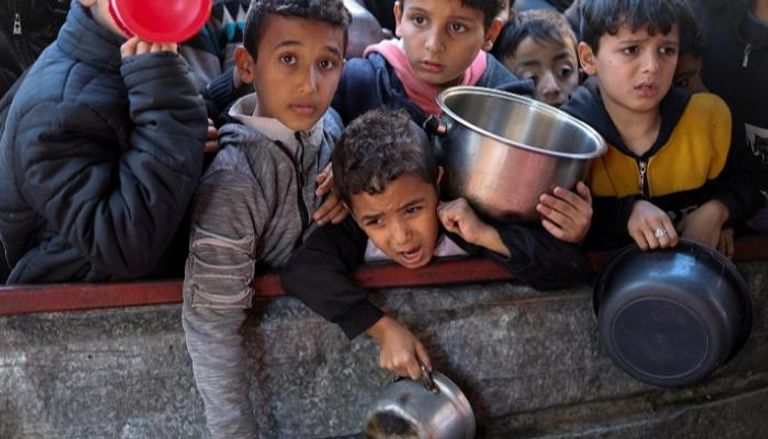 أطفال في غزة ينتظرون توزيع الطعام - رويترز