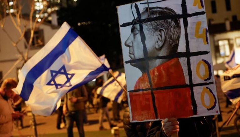 محتجون إسرائيليون يرفعون لافتة مناهضة لنتنياهو