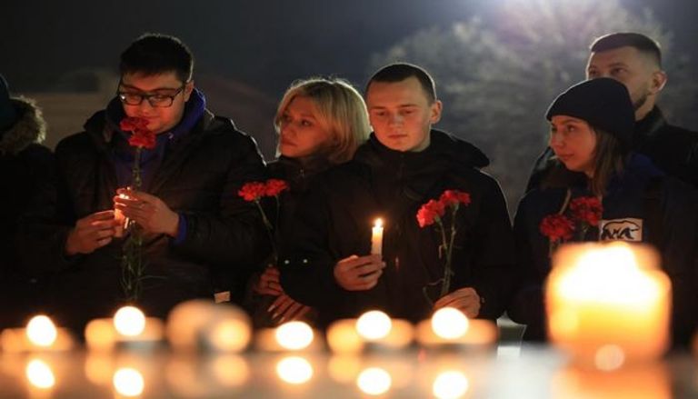 أشخاص يضعون الزهور ويشعلون الشموع تخليدًا لذكرى ضحايا الهجوم