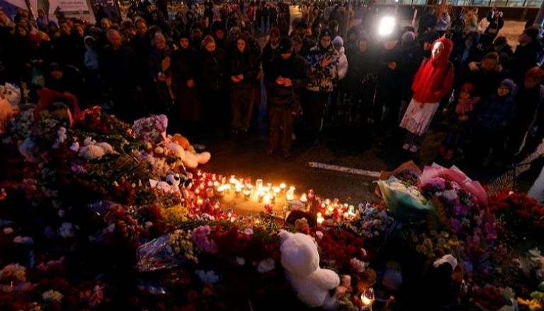 مواطنون روس يضعون زهورا حدادا على ضحايا الهجوم - رويترز