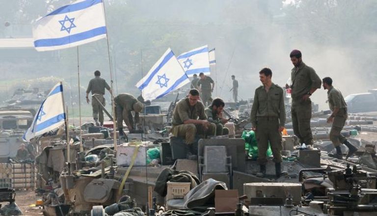 جنود إسرائيليون فوق آلياتهم - رويترز