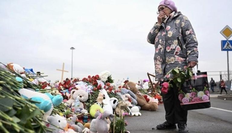 امرأة تقف عند نصب تذكاري مستحدث لضحايا هجوم موسكو 