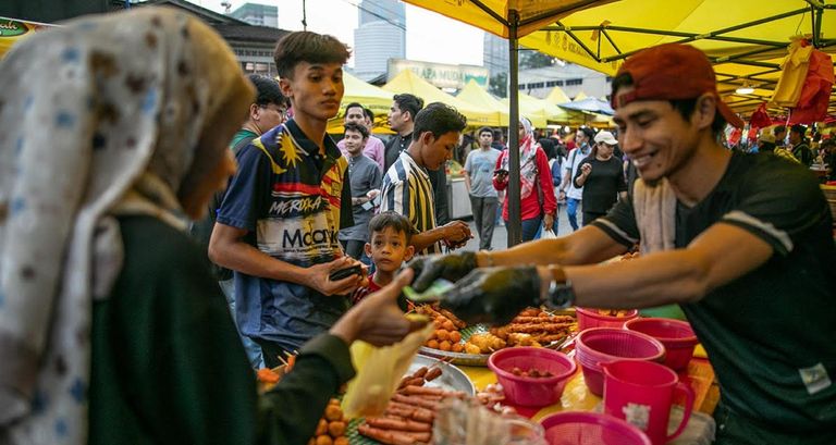 أجواء الحشود التي تزور البازار الرمضاني في كغ بارو لشراء أطباق الإفطار الشهية في كوالالمبور في 3 أبريل 2024. متطوعون يجمعون طعاما تبرع به أحد البازارات لصالح الفقراء في كوالالمبور