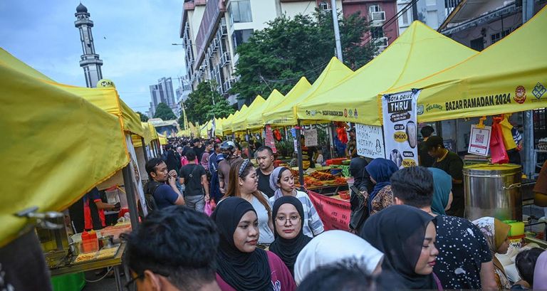 أجواء الحشود التي تزور البازار الرمضاني في كغ بارو لشراء أطباق الإفطار الشهية في كوالالمبور في 3 أبريل 2024. متطوعون يجمعون طعاما تبرع به أحد البازارات لصالح الفقراء في كوالالمبور