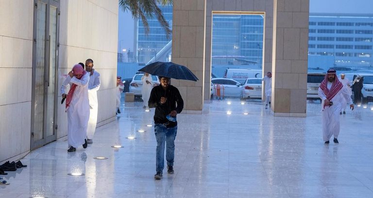 شاب يسير تحت المطر