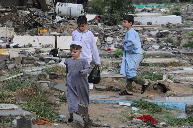 أسرة فلسطينية تزور المقابر بغزة - أ.ف.ب