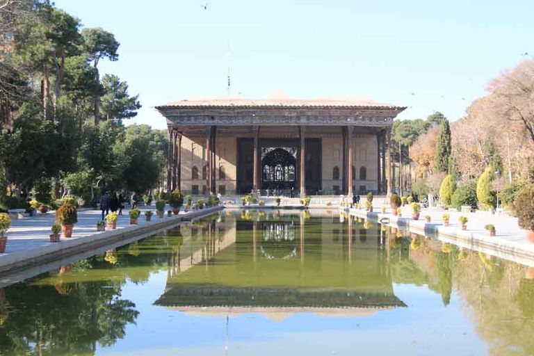 زوار يلتقطون الصور بجوار النافورة في ساحة نقش جهان التاريخية