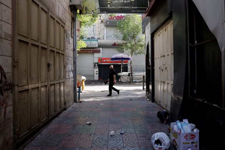 إضراب شامل في الضفة الغربية سيدة فلسطينية تمر أمام منزل مدمر جراء الاعتداء الإسرائيلي على نور شمس