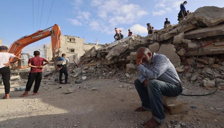 عمال الإنقاذ يبحثون عن ناجين تحت أنقاض مبنى أصيب في قصف إسرائيلي برفح