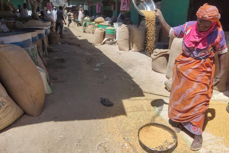 سوداني ينقل شوالا من محصول على ظهره - AFP