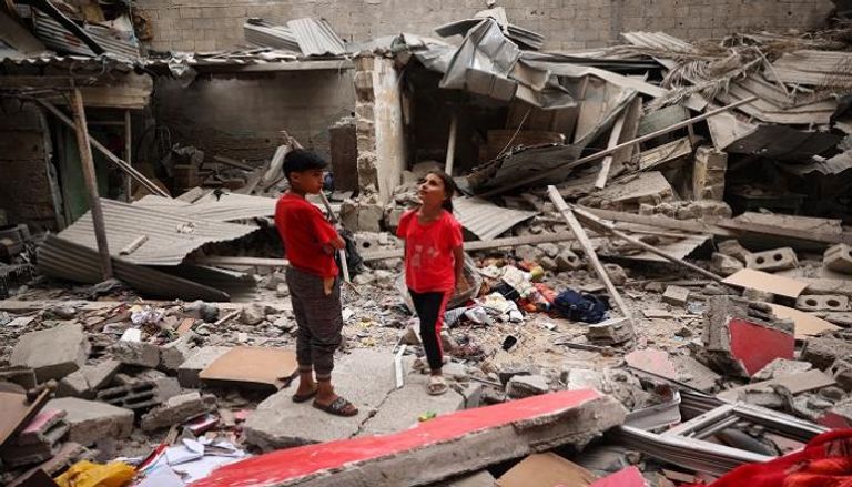 أطفال فوق ركام منزلهم المدمر بغزة