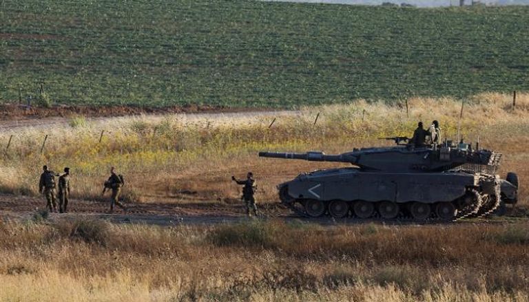 جنود إسرائيليون يتقدمون دبابة قرب الحدود مع قطاع غزة