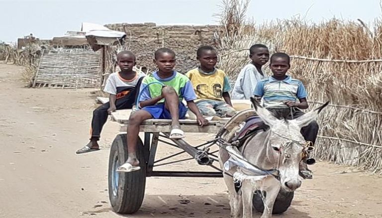 أطفال فوق ظهر عربة يجرها حمار بالسودان 