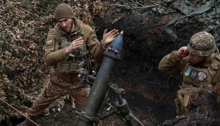 جنديان أوكرانيان يستعدان لإطلاق قذيفة من مدفع هاوتزر ذاتية الدفع عيار 109