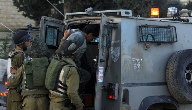 جنود إسرائيليون يعتقلون فلسطينيا بالضفة الغربية - أرشيفية