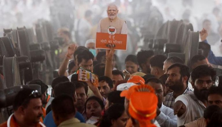 مناصر يرفع صورة مودي خلال تجمع انتخابي في الهند
