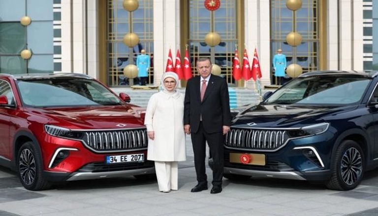 الرئيس التركي وقرينته مع السيارة 