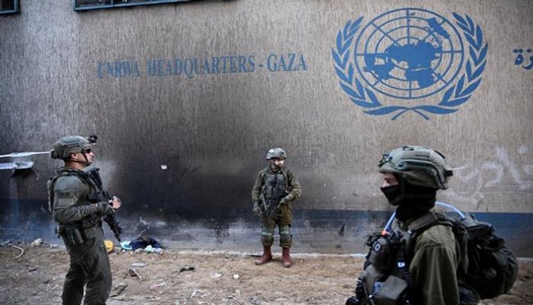 جنود إسرائيليون أمام مقر الأونروا في غزة - رويترز