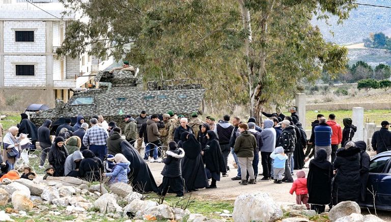 لبنانيون يقفون عند حاجز أقامه الجيش الإسرائيلي على أبواب بلدات حدودية