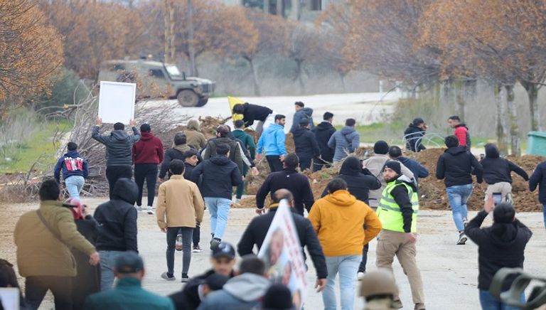 لبنانيون يقفون عند حاجز أقامه الجيش الإسرائيلي على أبواب بلدات حدودية