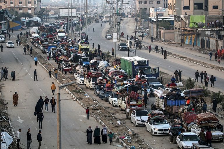 فلسطينية تحتضن طفلها بينما تنتظر السماح بالعودة إلى شمال غزة