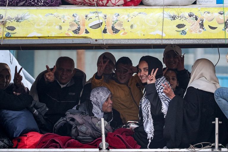 فلسطينية تحتضن طفلها بينما تنتظر السماح بالعودة إلى شمال غزة