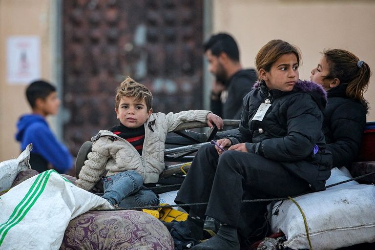 فلسطينية تحتضن طفلها بينما تنتظر السماح بالعودة إلى شمال غزة