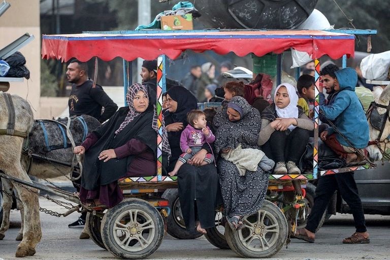 فلسطينية تحتضن طفلها بينما تنتظر السماح بالعودة إلى شمال غزة