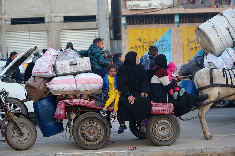 فلسطينية تحتضن طفلها بينما تنتظر السماح بالعودة إلى شمال غزة