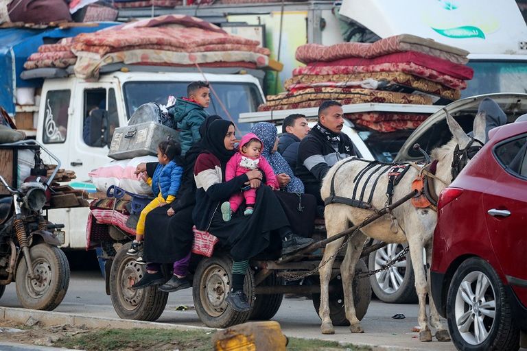فلسطينية تحتضن طفلها بينما تنتظر السماح بالعودة إلى شمال غزة