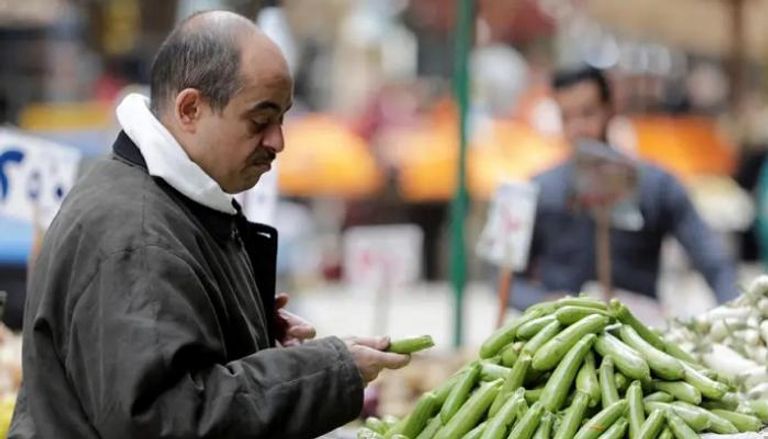 رجل يشتري الخضروات في سوق بمصر