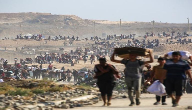 فلسطينيون يسيرون بين الأنقاض في غزة